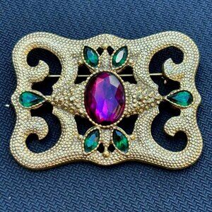 VINTAGE BROOCH IN GOLD, WITH PURPLE AND GREEN STONES.